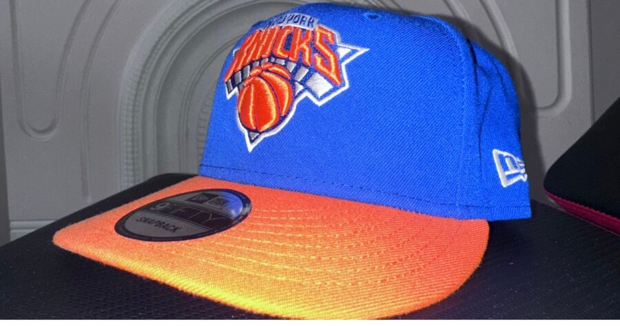 New York Knicks hat with orange and blue street style branding.