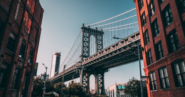 View of the Manhattan Bridge between brick buildings in Brooklyn New York highlighting the city environment