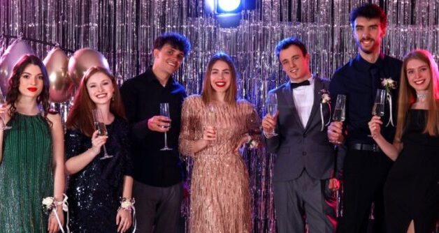 Group of well-dressed people posing with drinks at a formal 4/20 celebration event in New York City nightlife setting