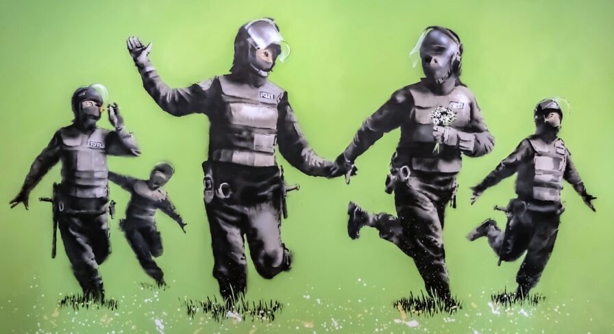 Banksy-style mural of riot police running while holding flowers