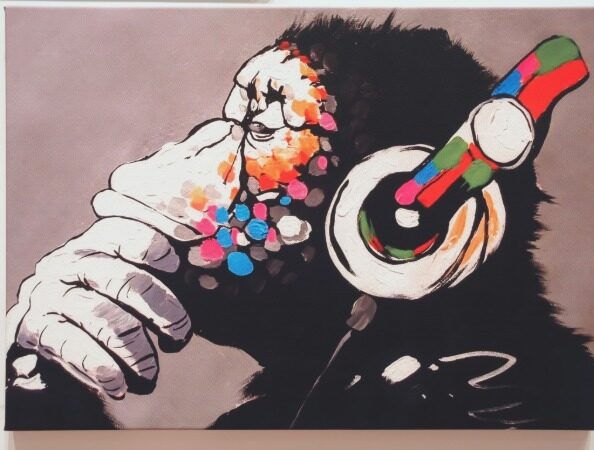 Banksy-style painting of a monkey wearing headphones with colorful details