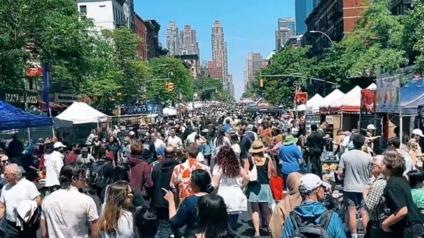 Visitors walking through the Fabulous 9th Avenue Street Fair in Hell's Kitchen, Manhattan, during one of New York City's largest annual street festivals.
