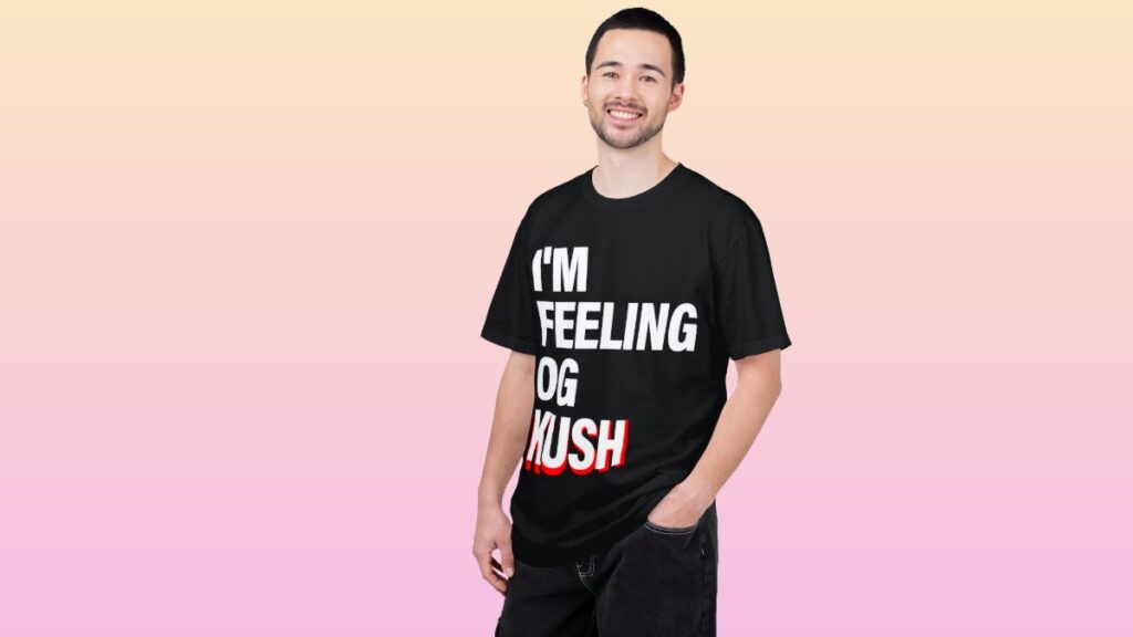 Man wearing black "I'm Feeling OG Kush" T-shirt on black background.